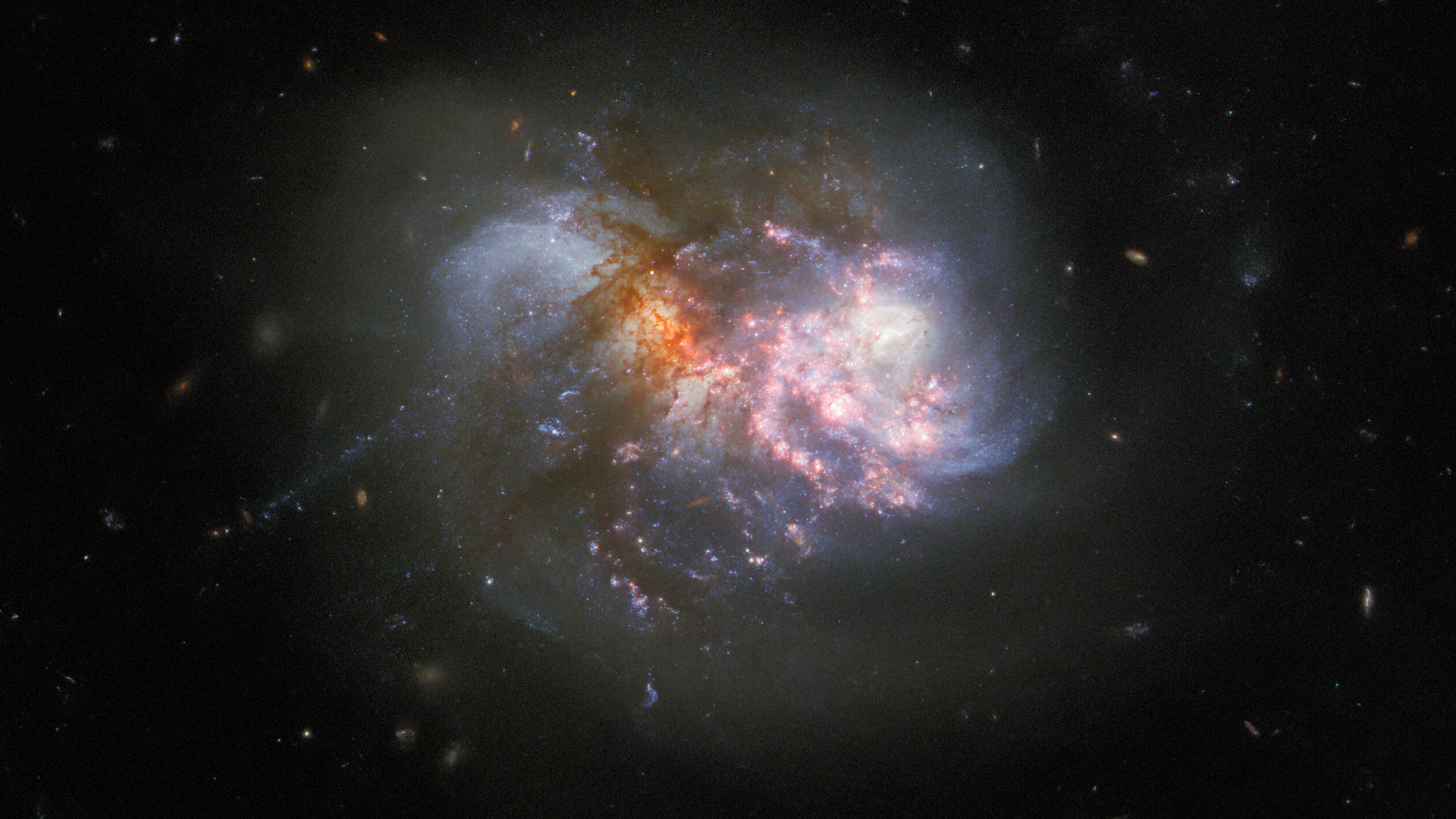 The Hubble Space Telescope captured two galaxies in the late stages of a colorful collision, collectively referred to as IC 1623. The image combines visible light with ultraviolet and infrared to give us a better look of what's going on amid all the chaos.