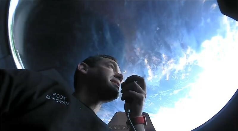 Jared Isaacman peering up through the ship's Dragon cupola.