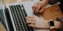 hands type on a macbook