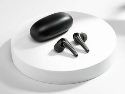 black earbuds with skinny stems next to round charging case