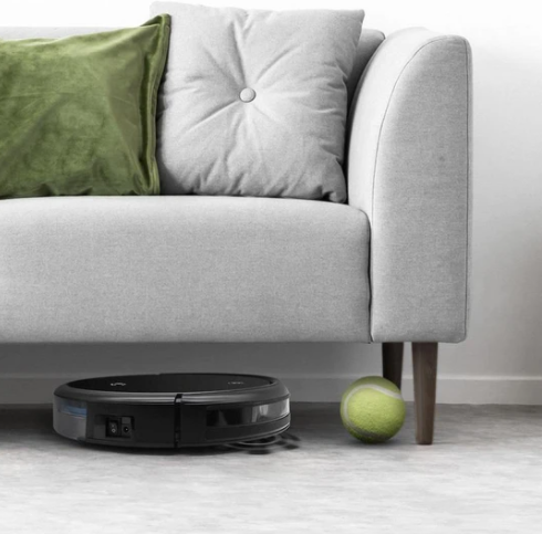 robovac going underneath couch beside tennis ball