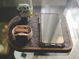 Apple Watch, Airpods, and iPhone on wood and gray felt charging pad