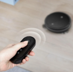 woman holding remote controlling a robovac