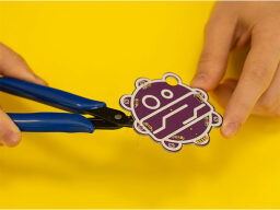 Pliers putting wire into place on robot held in hands