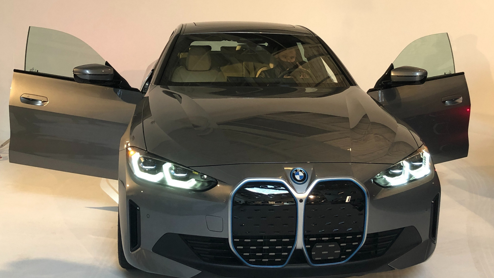 A silver car with its doors open.