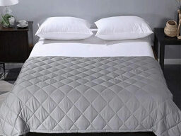 White bed with grey quilted blanket