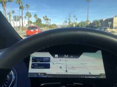 A map screen behind the steering wheel.