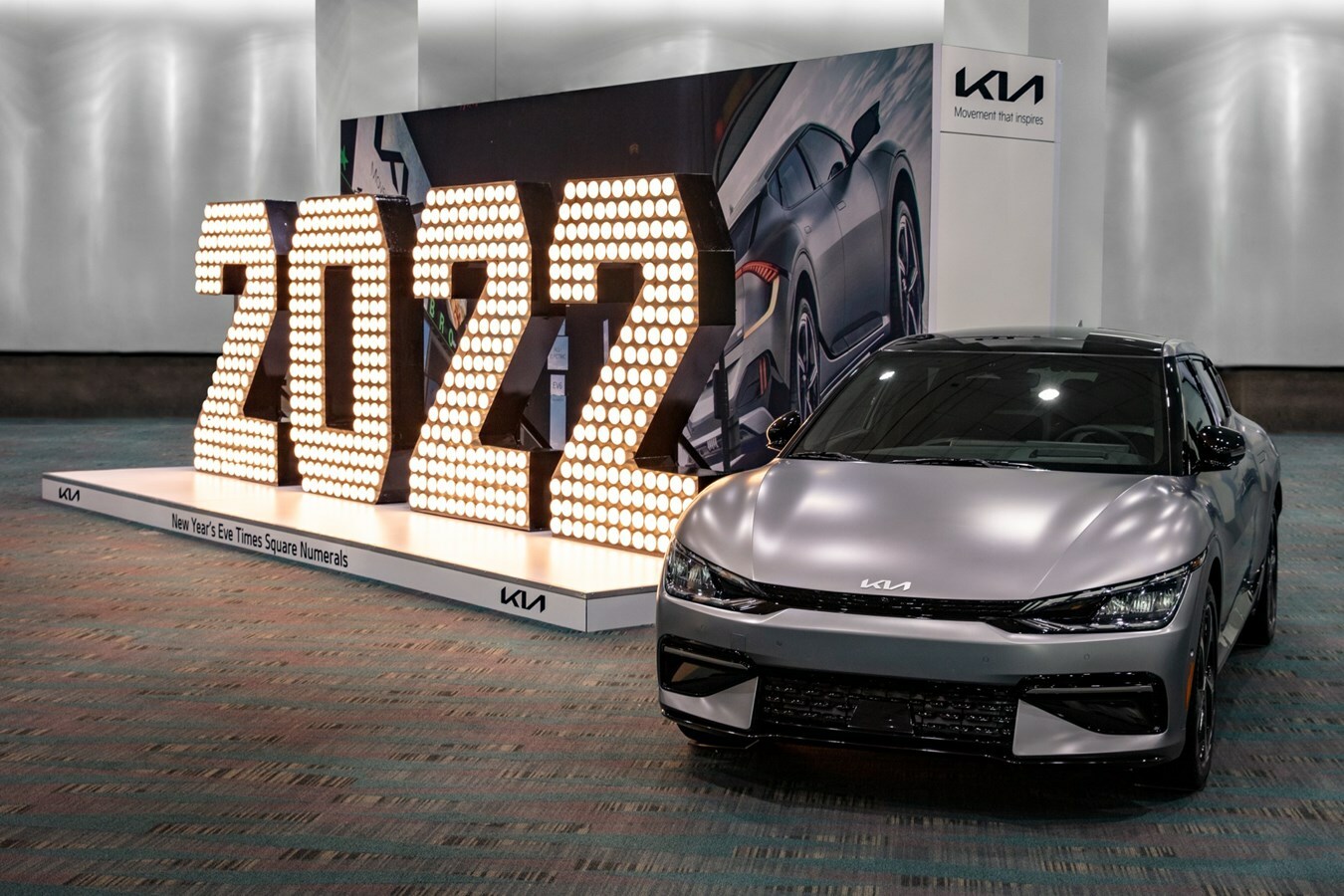 A large 2022 sign with a silver car next to it.