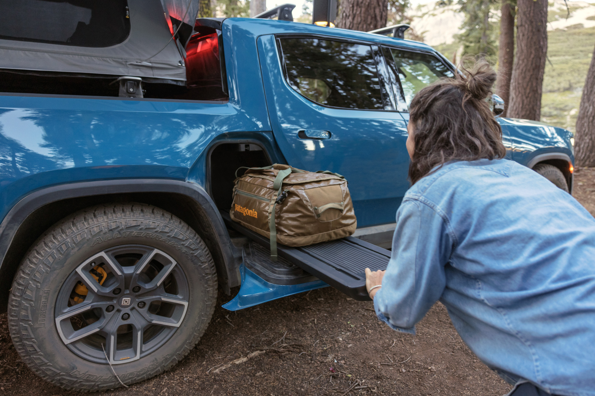 A blue truck with gear in the back and in compartments.