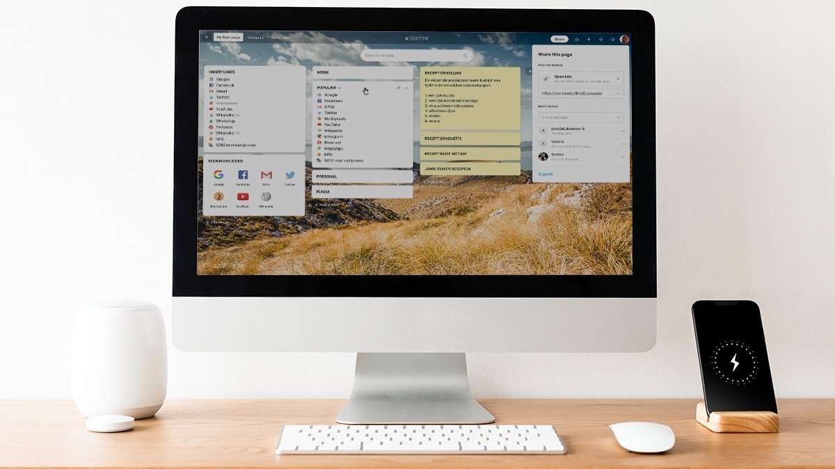 Computer with productivity tabs on screen, on desk next to phone and speaker