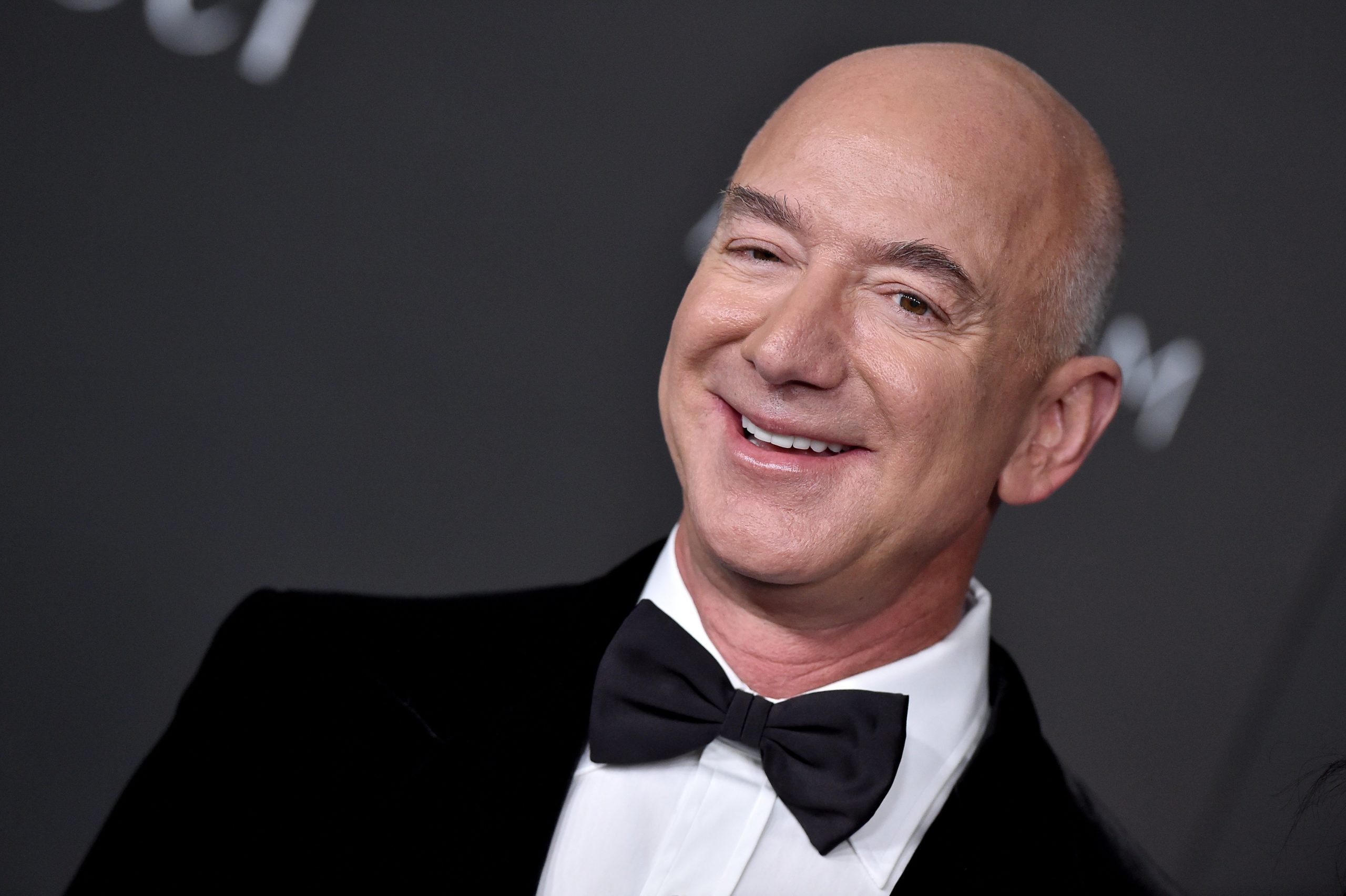 Former Amazon CEO Jeff Bezos wearing a tuxedo and smiling.