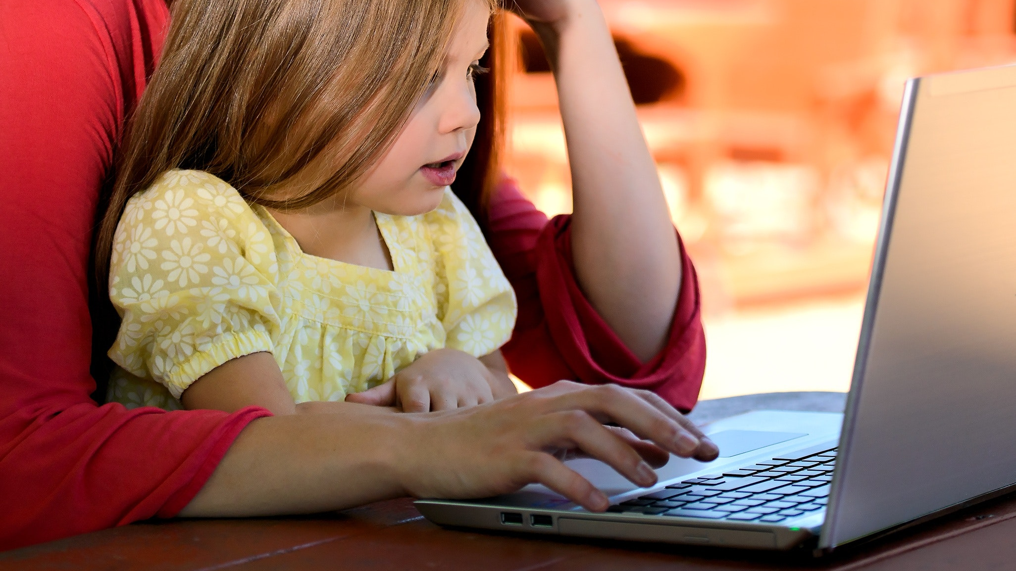 A parent and child working on a laptop