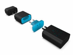Black and blue travel adapter separated into four sections with separate plugs and outlets