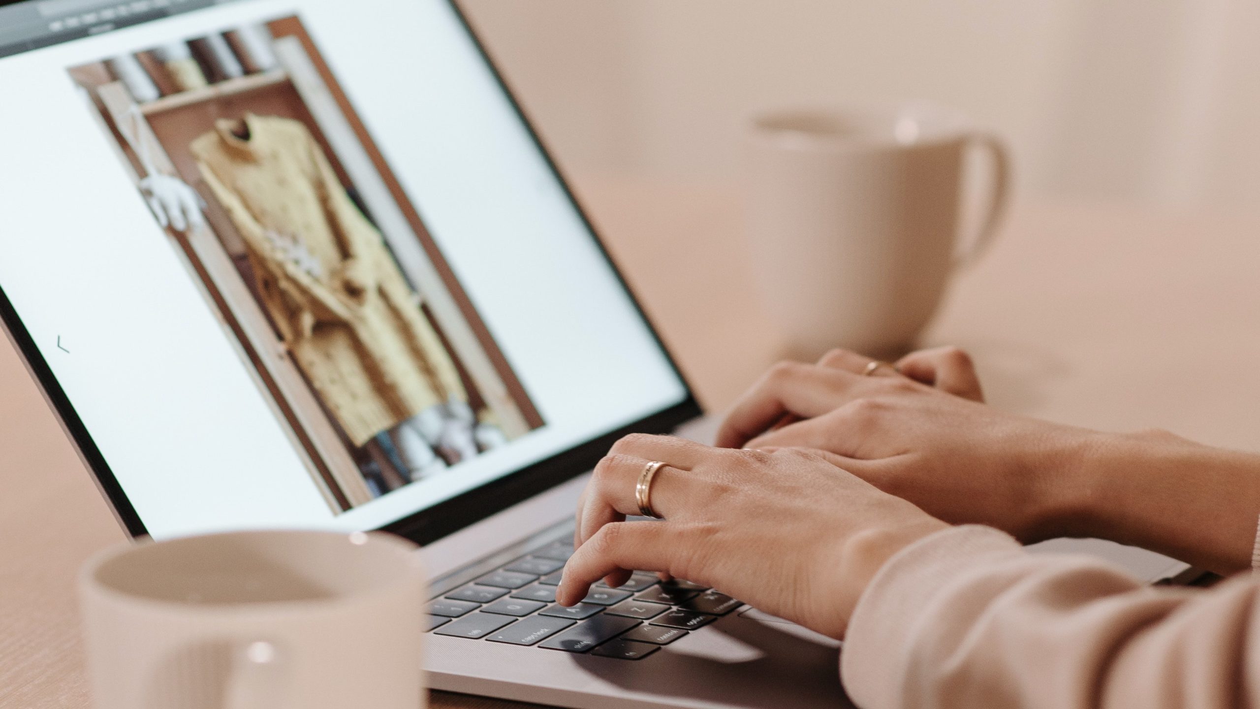 Hands on laptop showing image of clothing