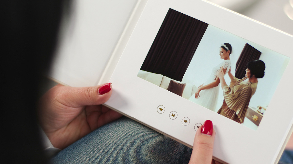 Person holding book with play, pause, fast forward, and rewind buttons under image