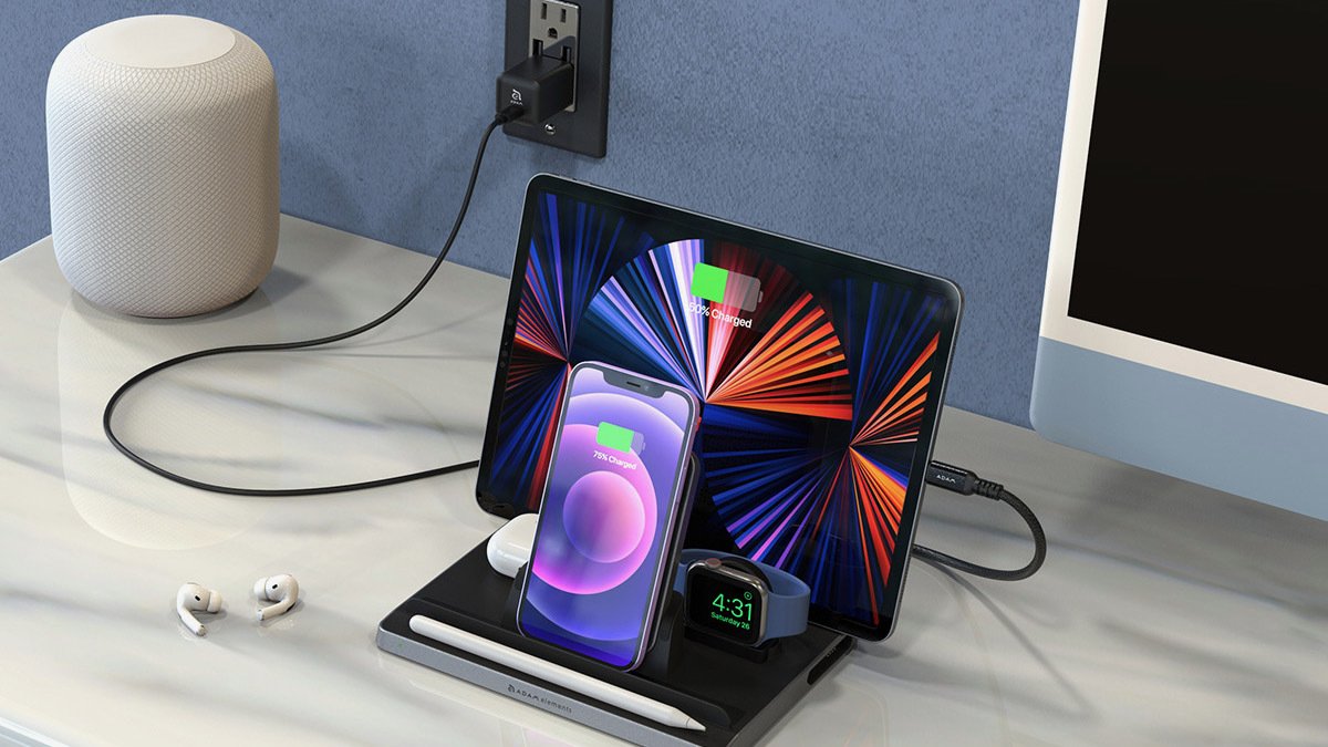 Black charger plugged into wall and charging apple watch, iphone, ipad, stylus, and airpods