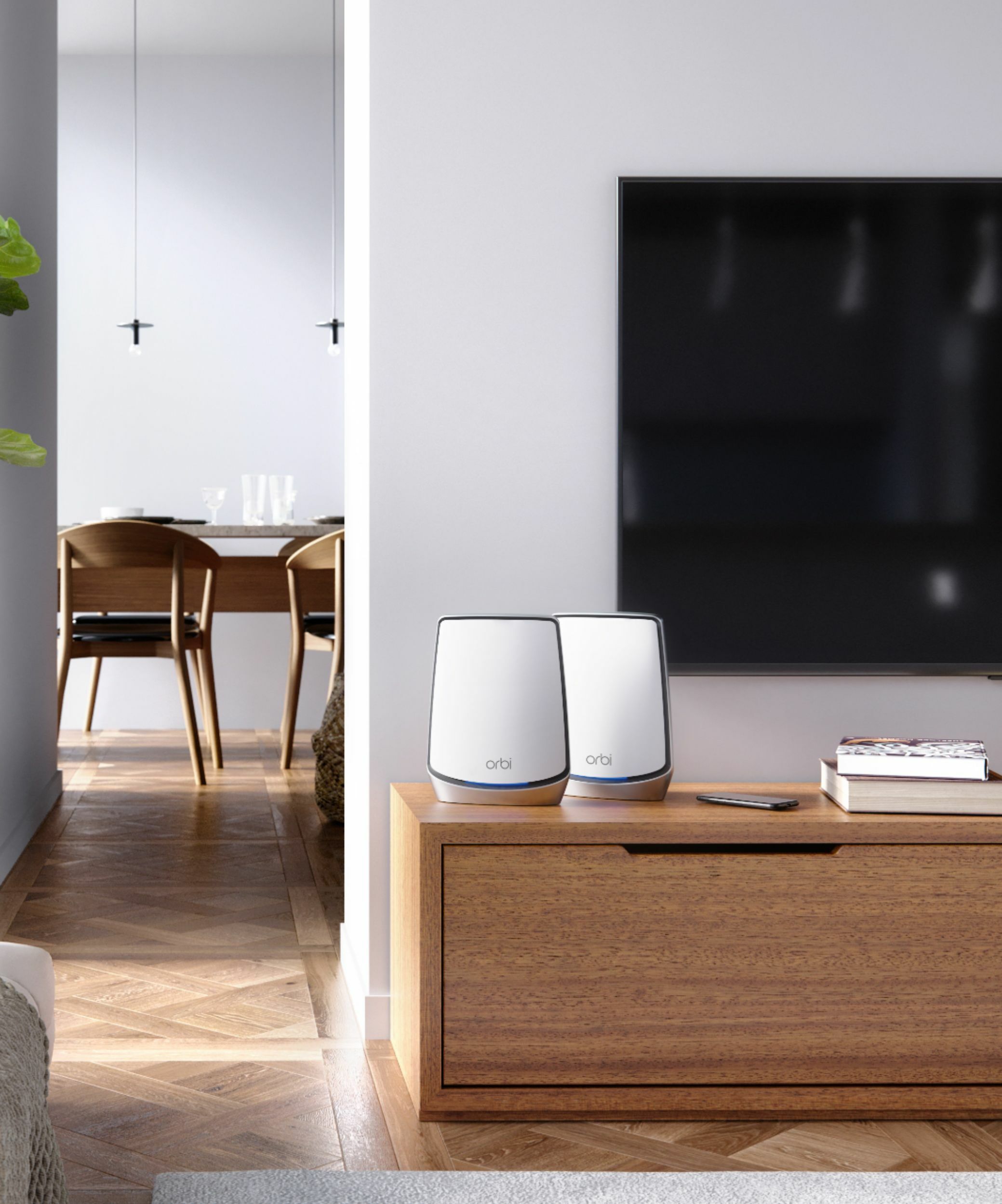 NETGEAR Orbi Whole Home Tri-Band Mesh WiFi on a table.