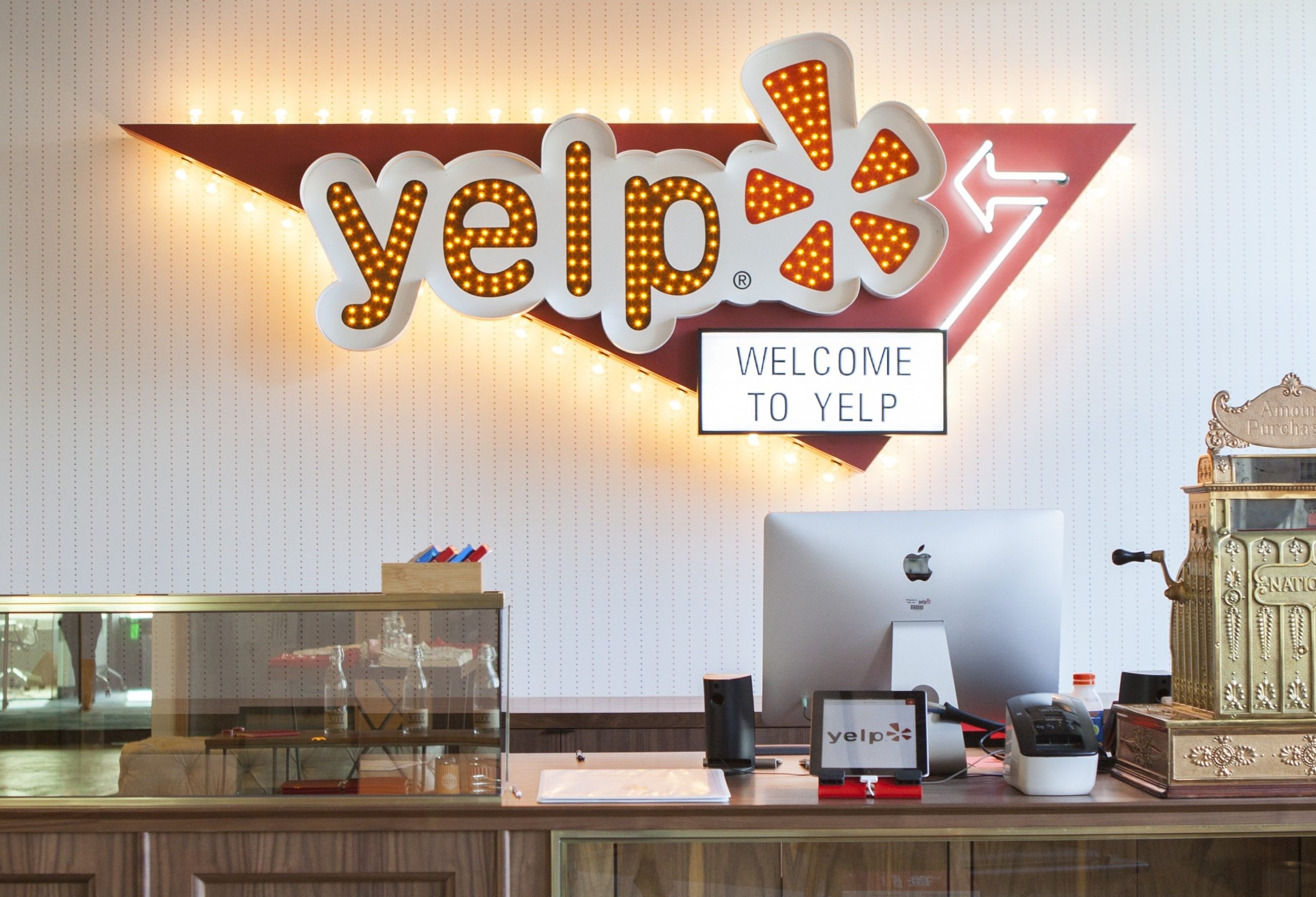 The entry to Yelp's office in San Francisco, with a Yelp logo behind a large reception desk.