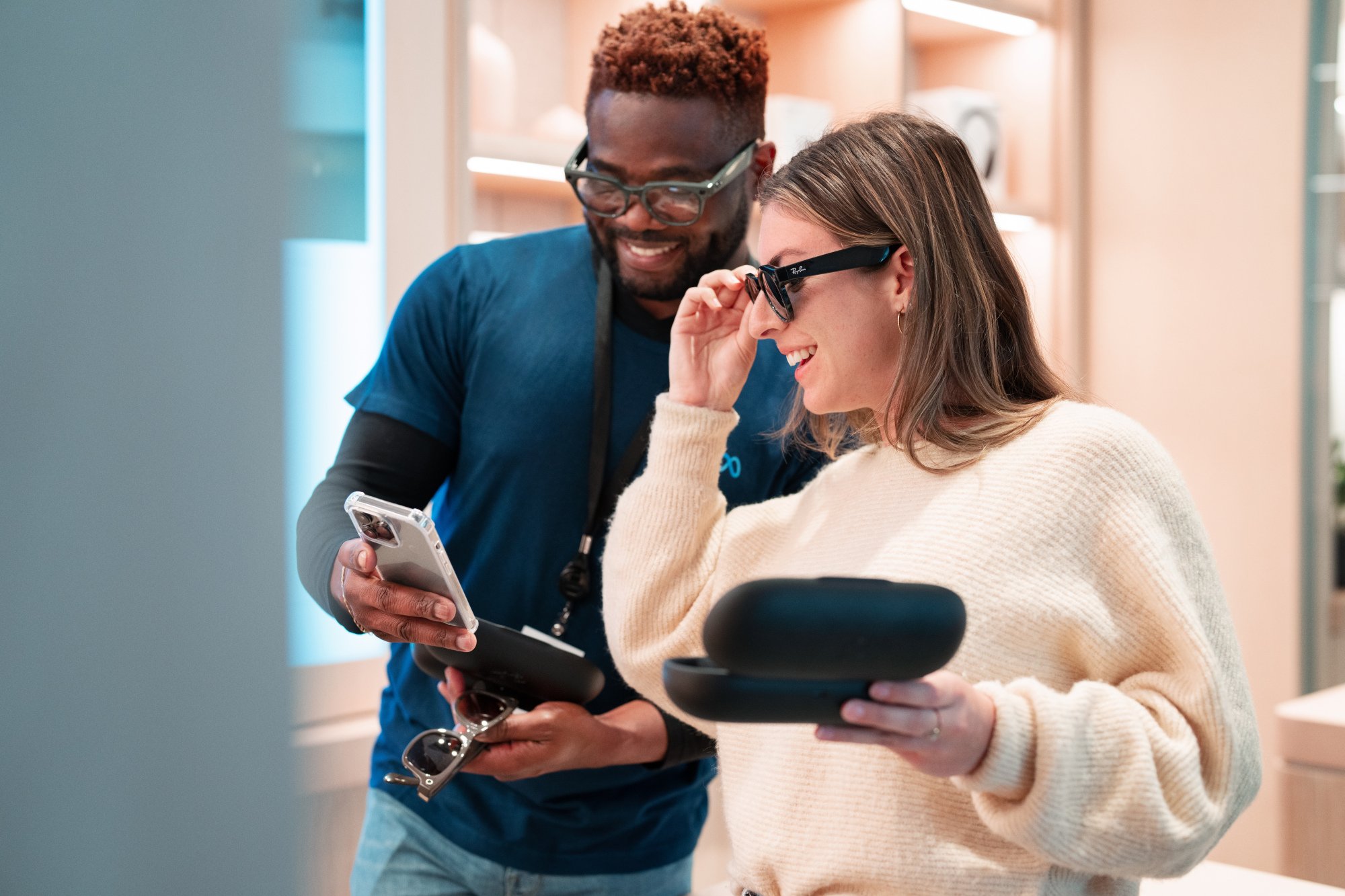 A Meta Store worker shows a woman Ray-Ban glasses.