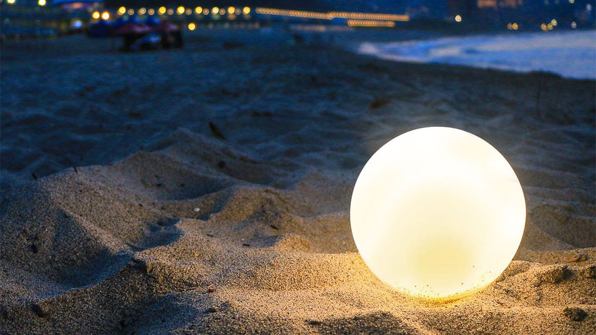 White round lamp on sand at beach