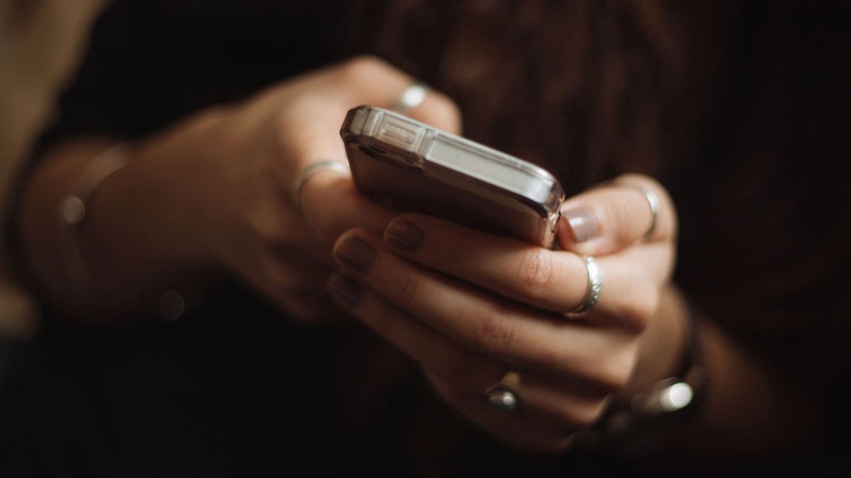 Hands wearing rings holding a phone