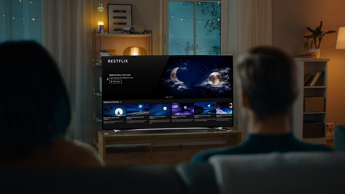 Backs of two heads looking at TV showing restflix screen