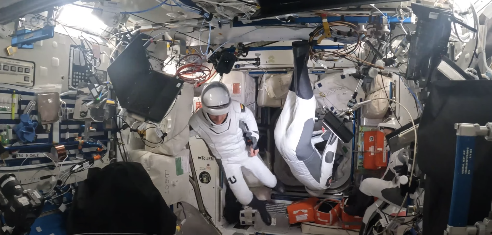 A screenshot of a video of astronauts in their spacesuits dancing to the waltz.