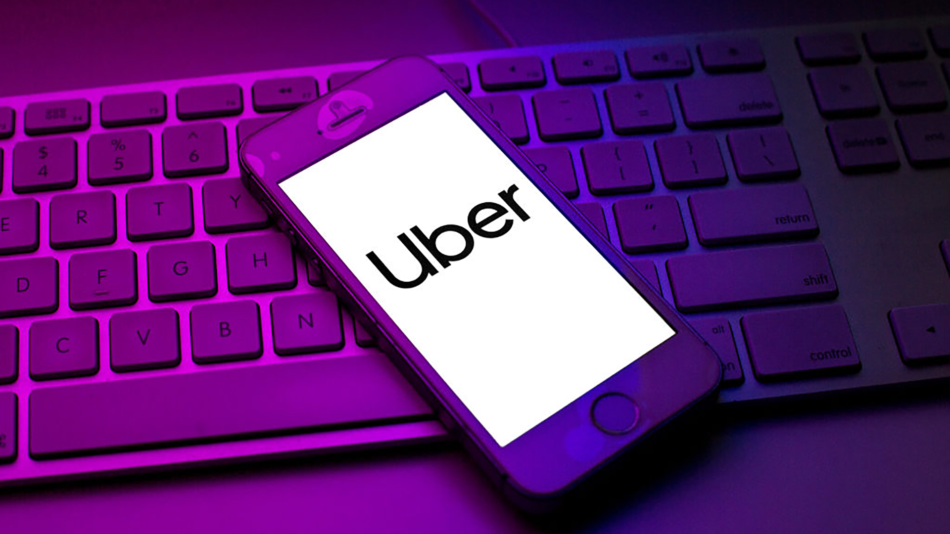 phone with uber on top of keyboard