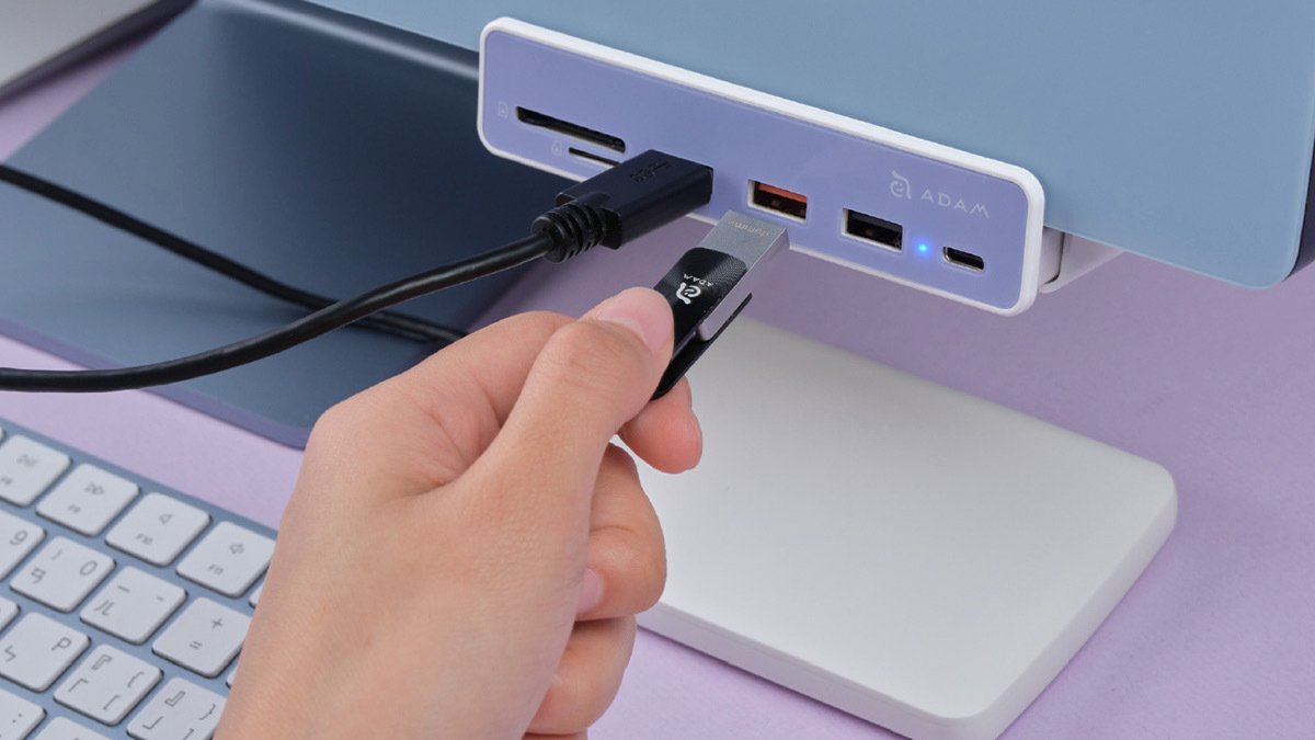 Person plugging in cable to adapter attached to computer