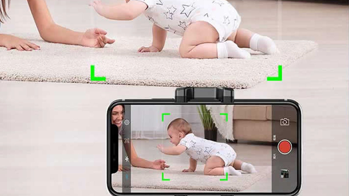 Phone held in black clamp recording baby crawling