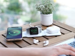 Phone, smartwatch, and earbuds case charging on white mat