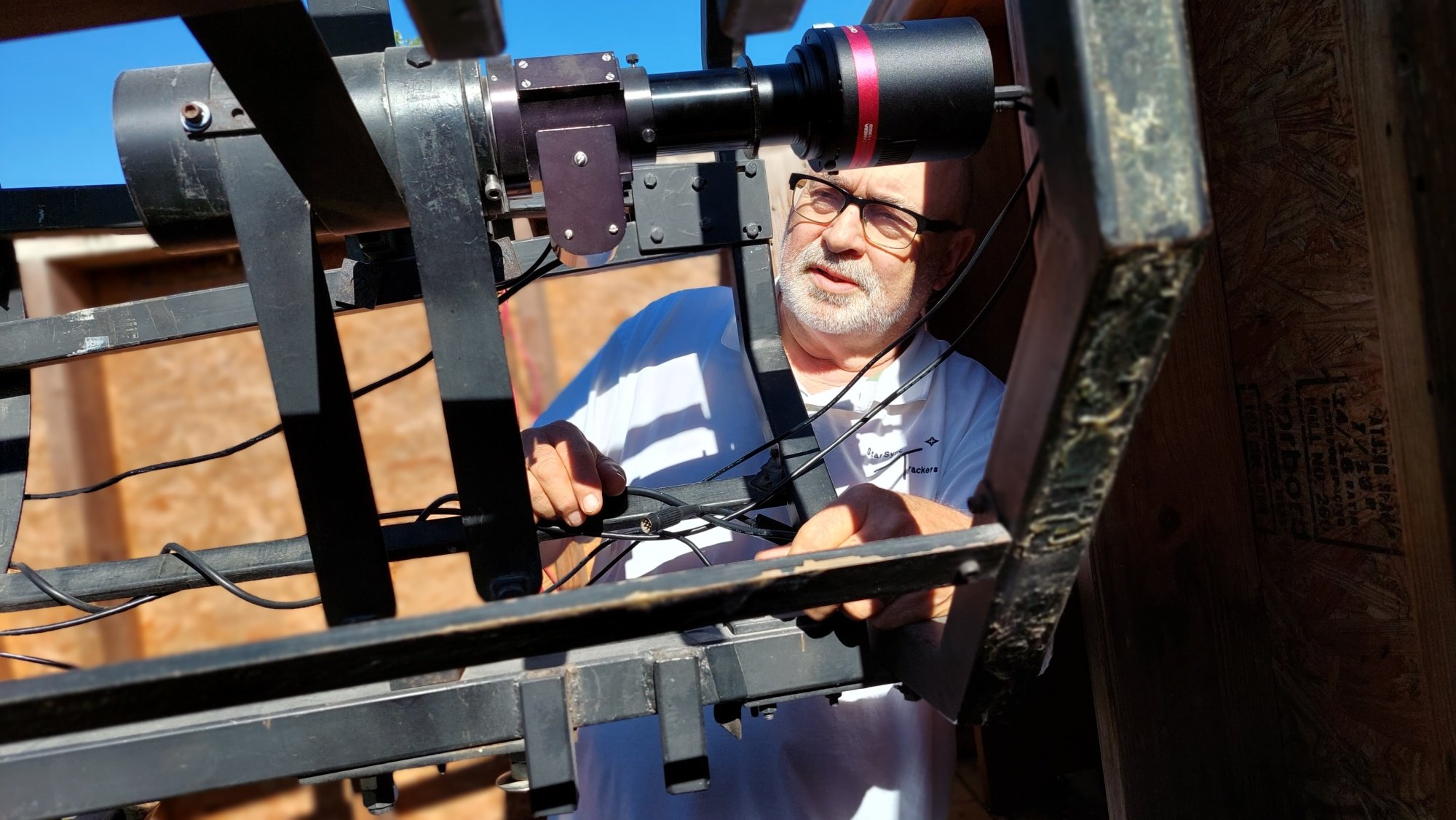 man working on telescope