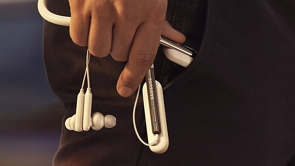 man's hand holding earphones