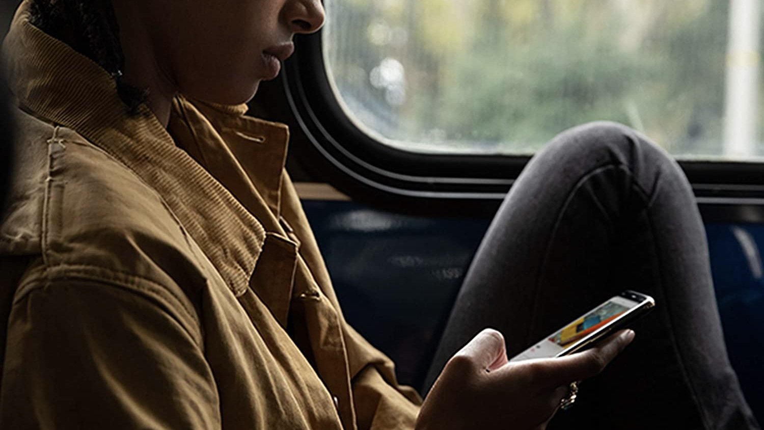 person on a train looking at their iphone