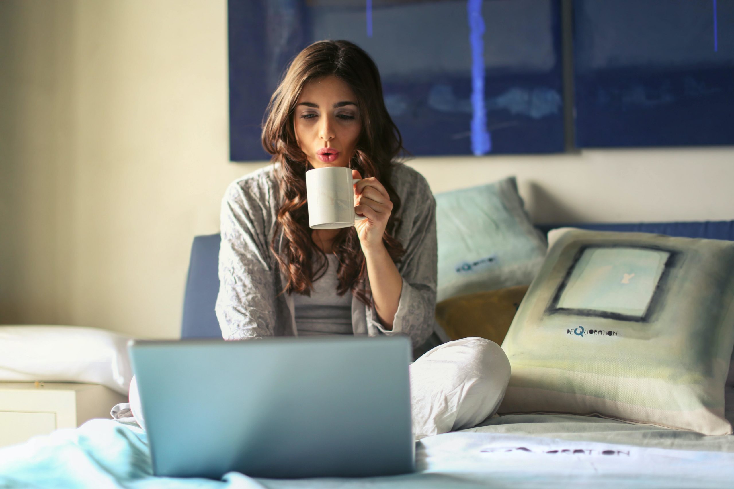 Girl watching laptop with mug