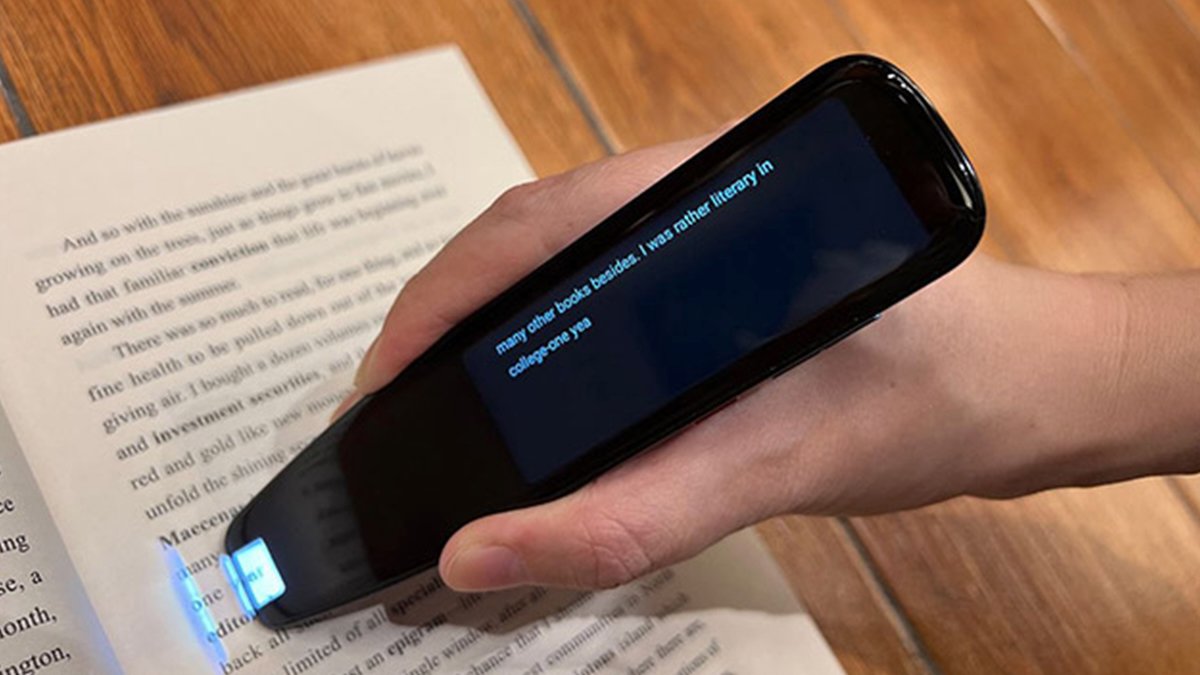 Hand holding black pen scanning text