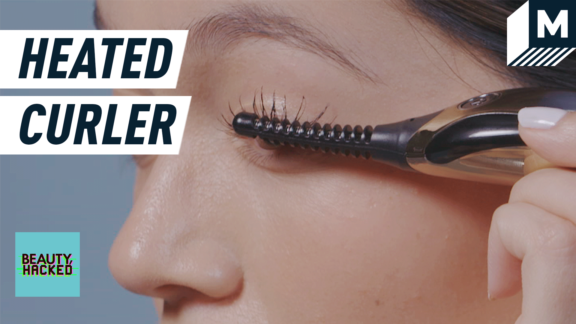 A close-up image of a woman using heated lash curler.