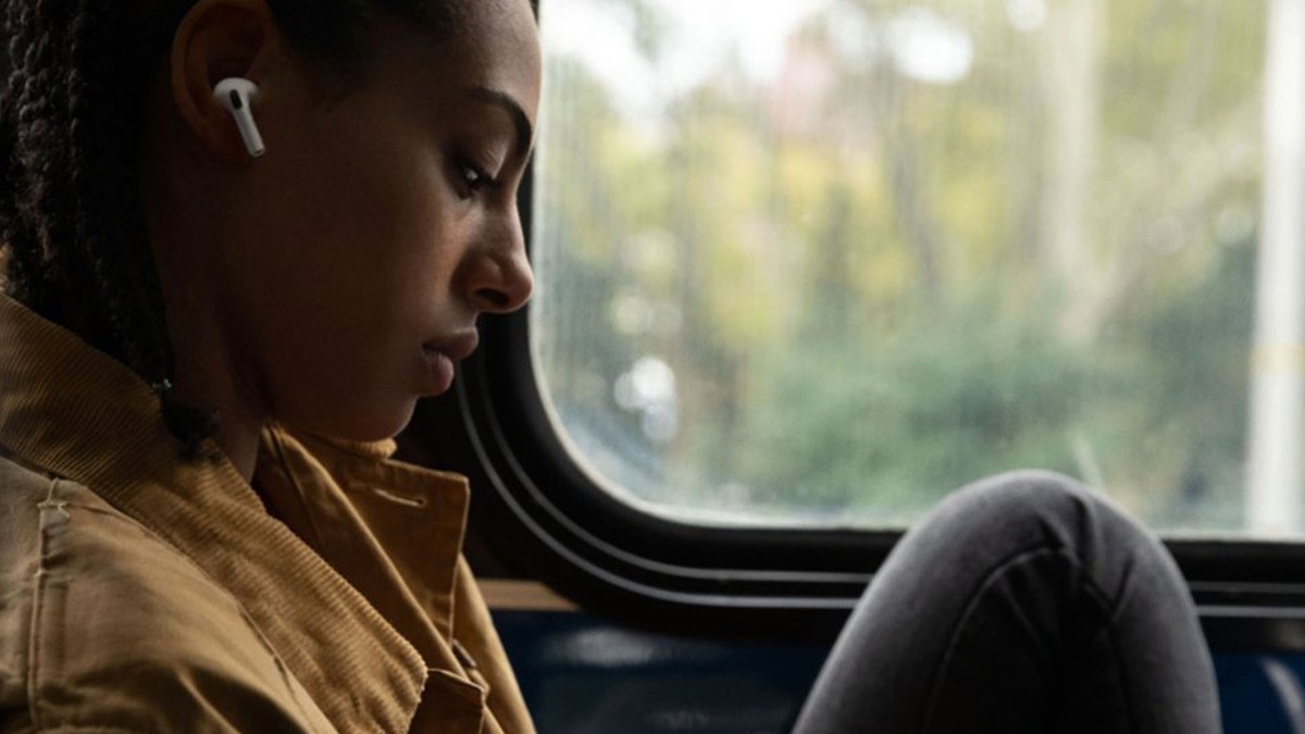 Person in profile looking down at phone with airpod in ear