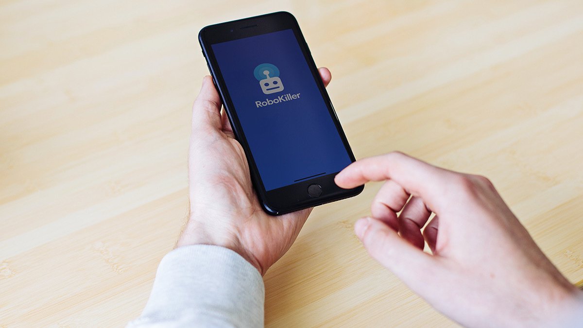 Hands holding phone showing robokiller app page