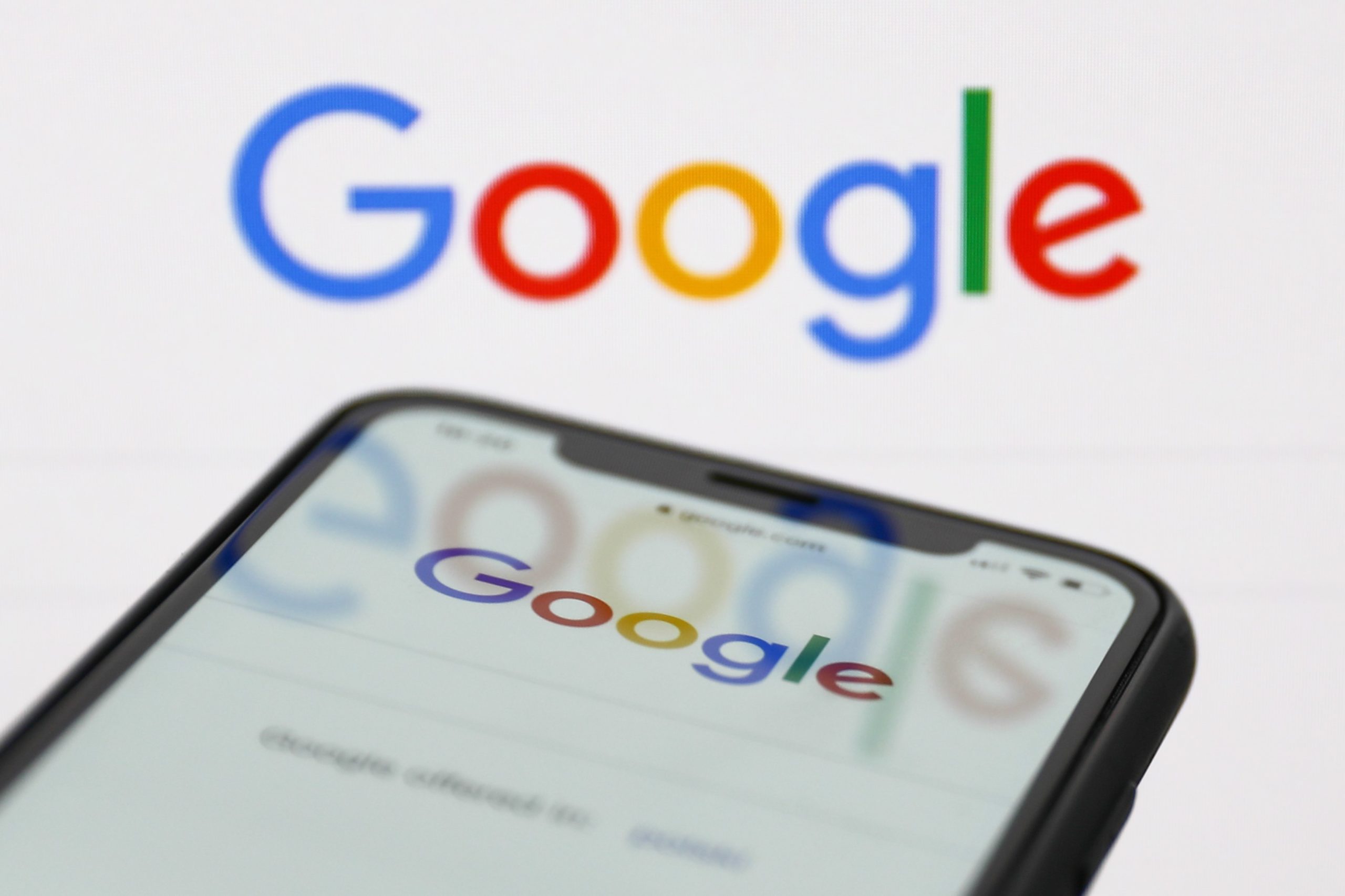 google logo hovers above phone displaying google home screen