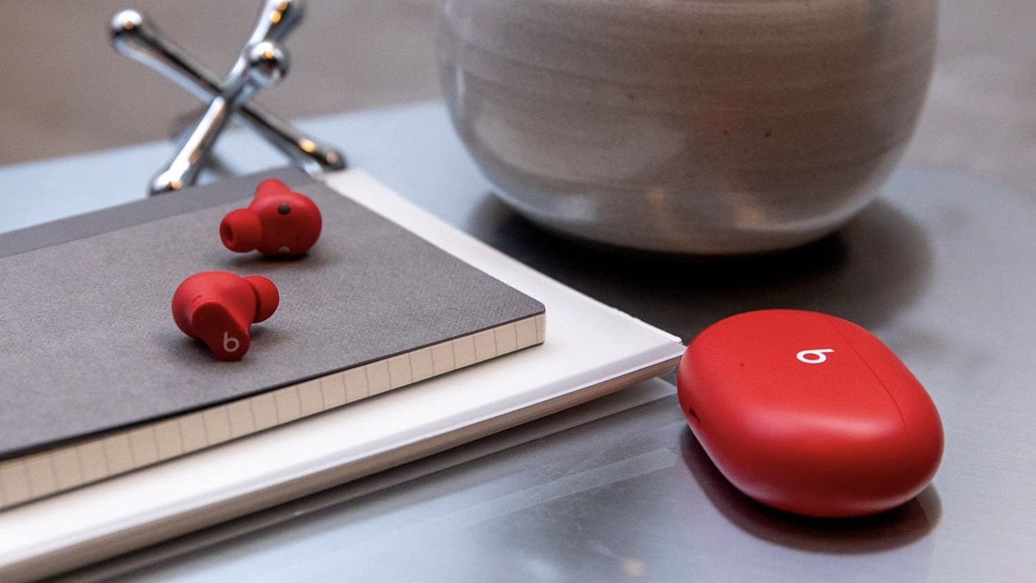 beats studio buds on top of a notebook on someone's desk