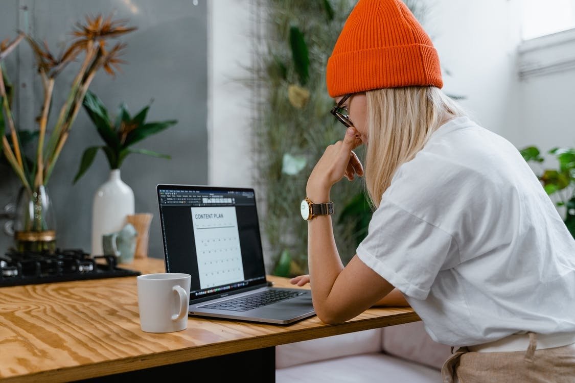 Person in orange hat using laptop