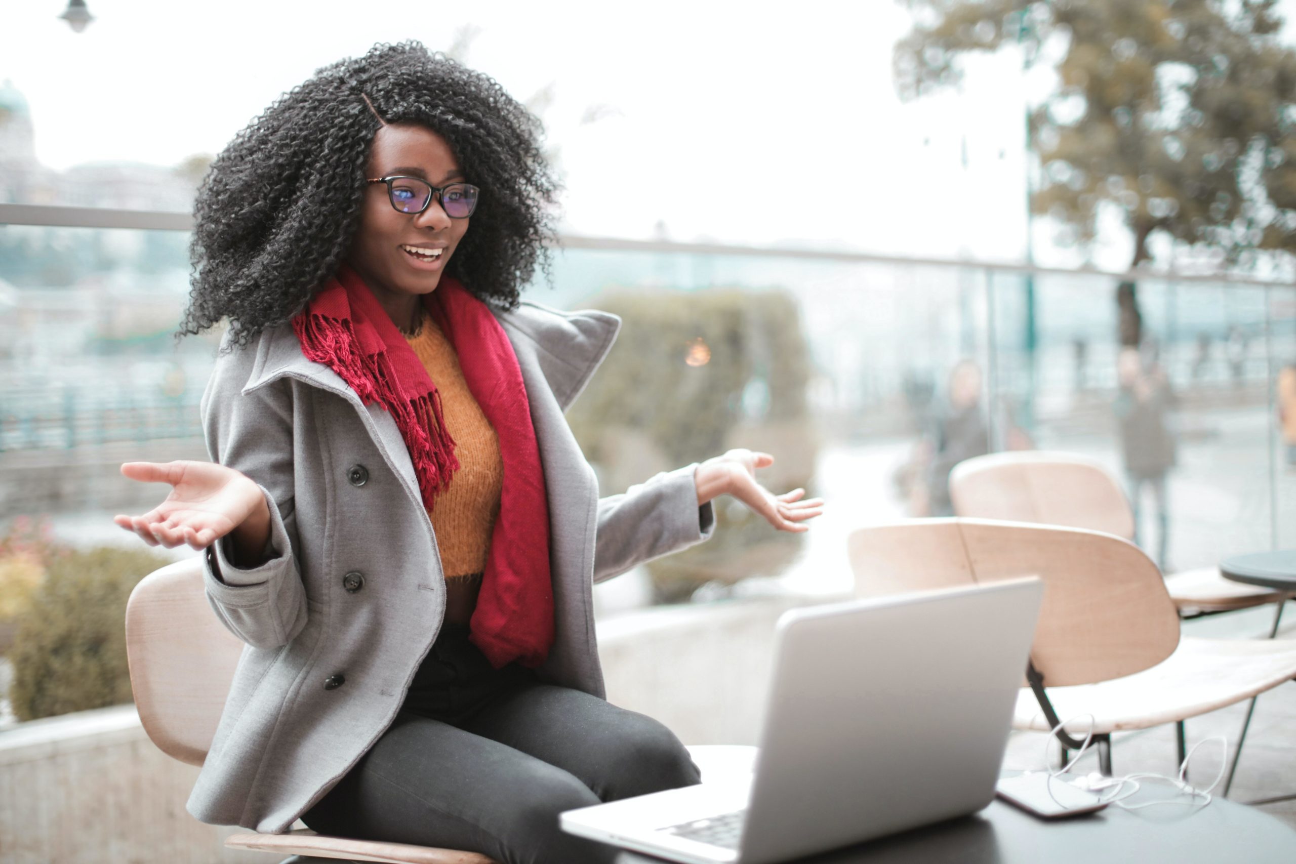 Person sitting outside with a laptop smiling.