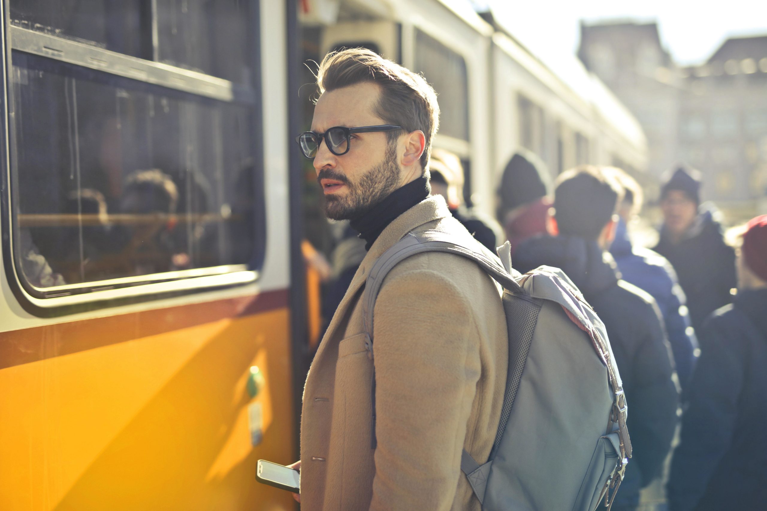 Man boarding. a train and wearing a backpack