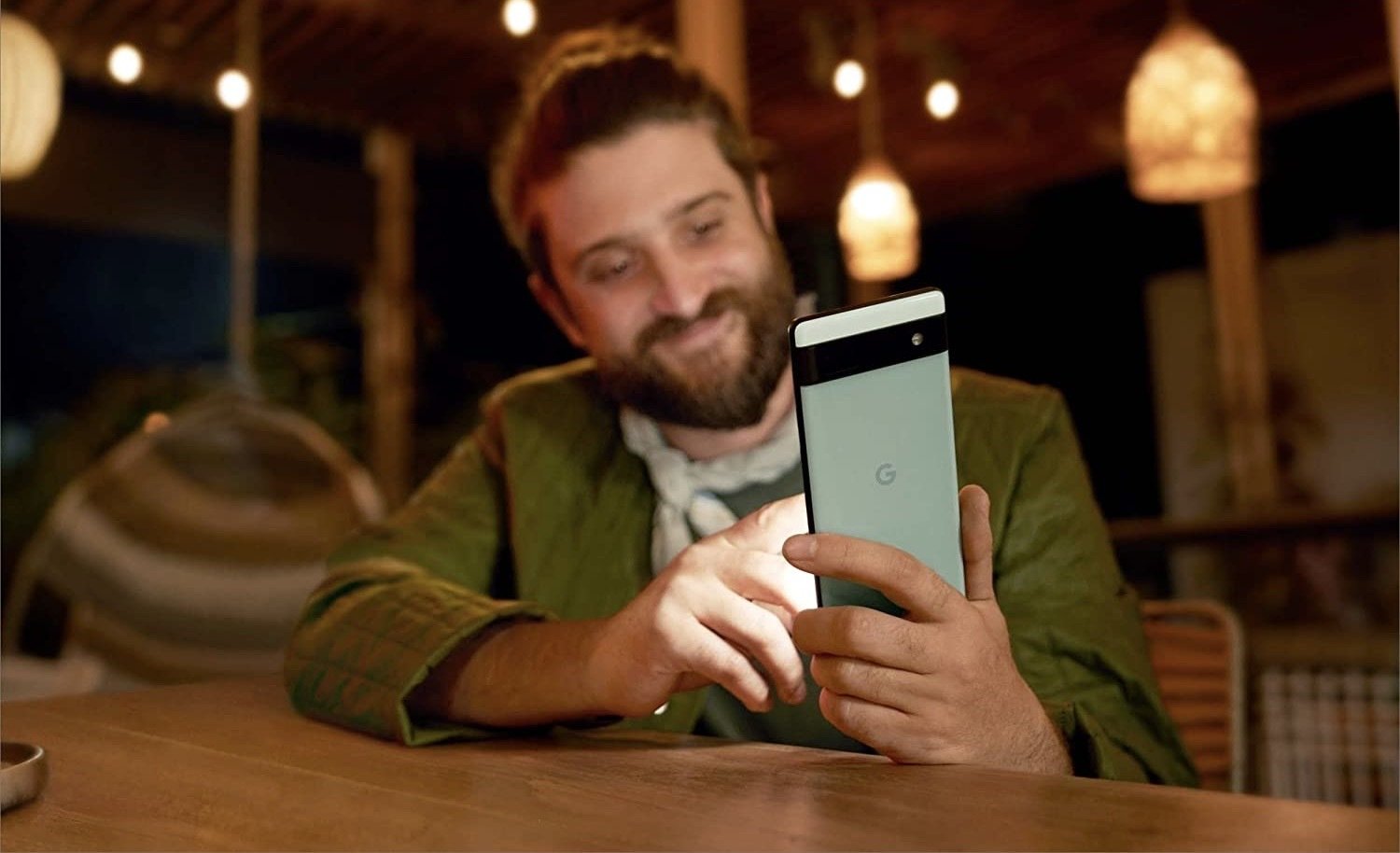 man sitting at bar smiling at phone