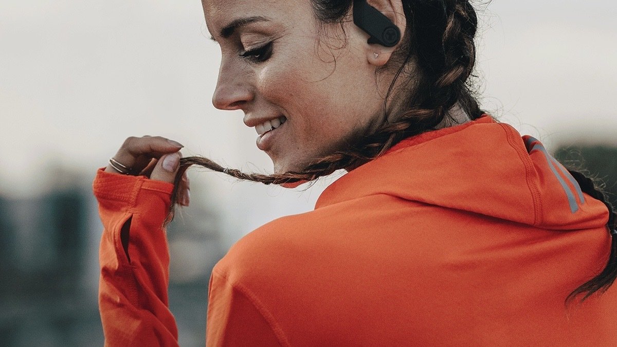 Person wearing a pair of TREBLAB X3 Pro Wireless Bluetooth Earbuds with Earhooks.