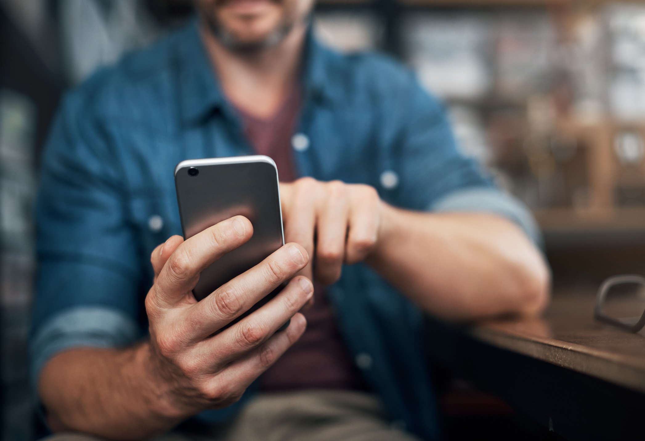 Man using a smartphone in a bar.
