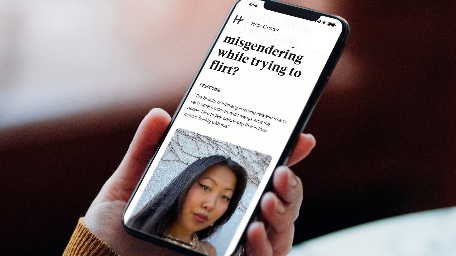 Hinge's new in-app educational guide for LGBTQ users is shown on a smartphone held in a hand.