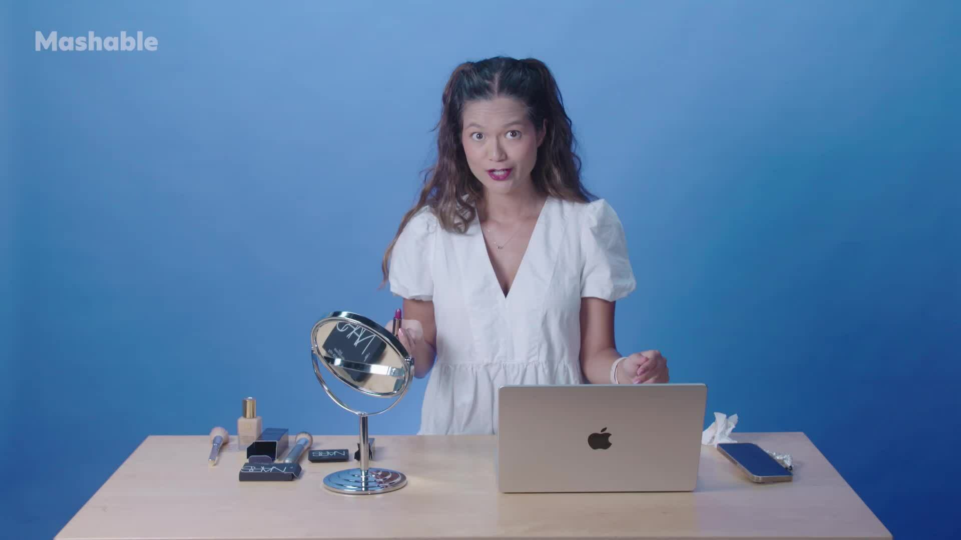 Mashable host Jennimai stands behind a table.