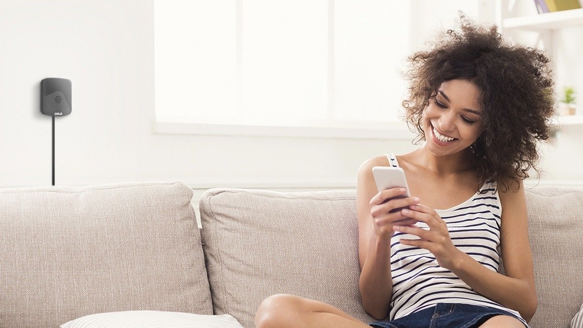 Person in a living room with the Cielo Breez Eco Smart A/C Controller in black.